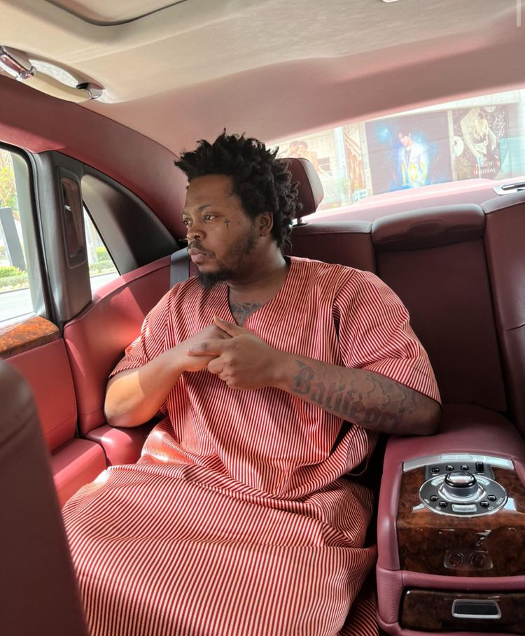 Olamide in a Rolls-Royce Ghost sedan