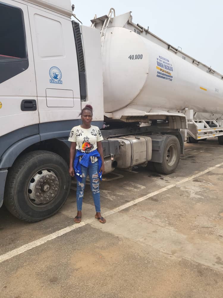 Yemi standing next to the fuel tanker she drives